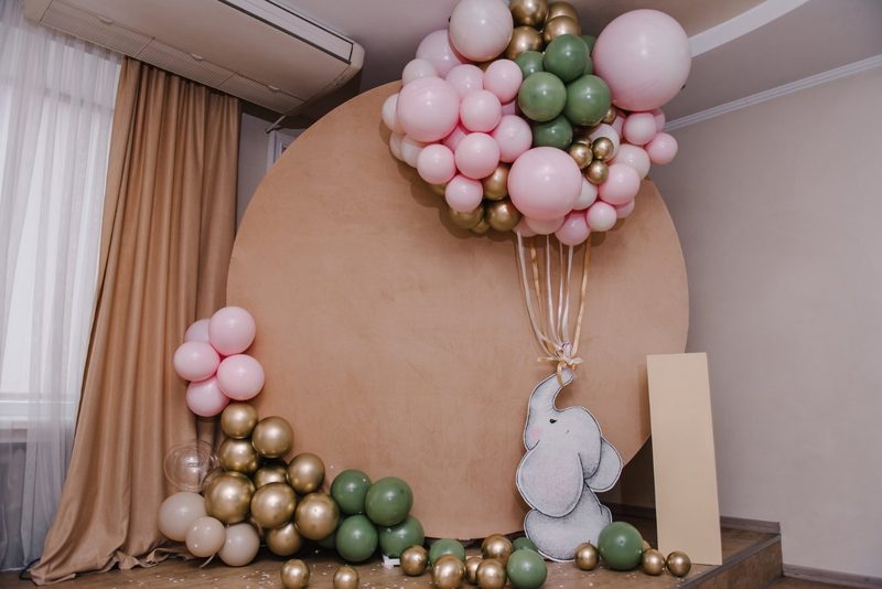 Round backdrop styled with blush, sage and gold balloons