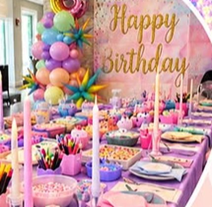 Long party table set with candles, linens and a custom backdrop